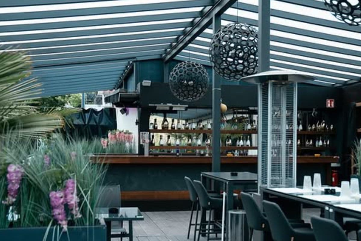 Die Terrassenbar unter dem Glasdach mit Pflanzen
